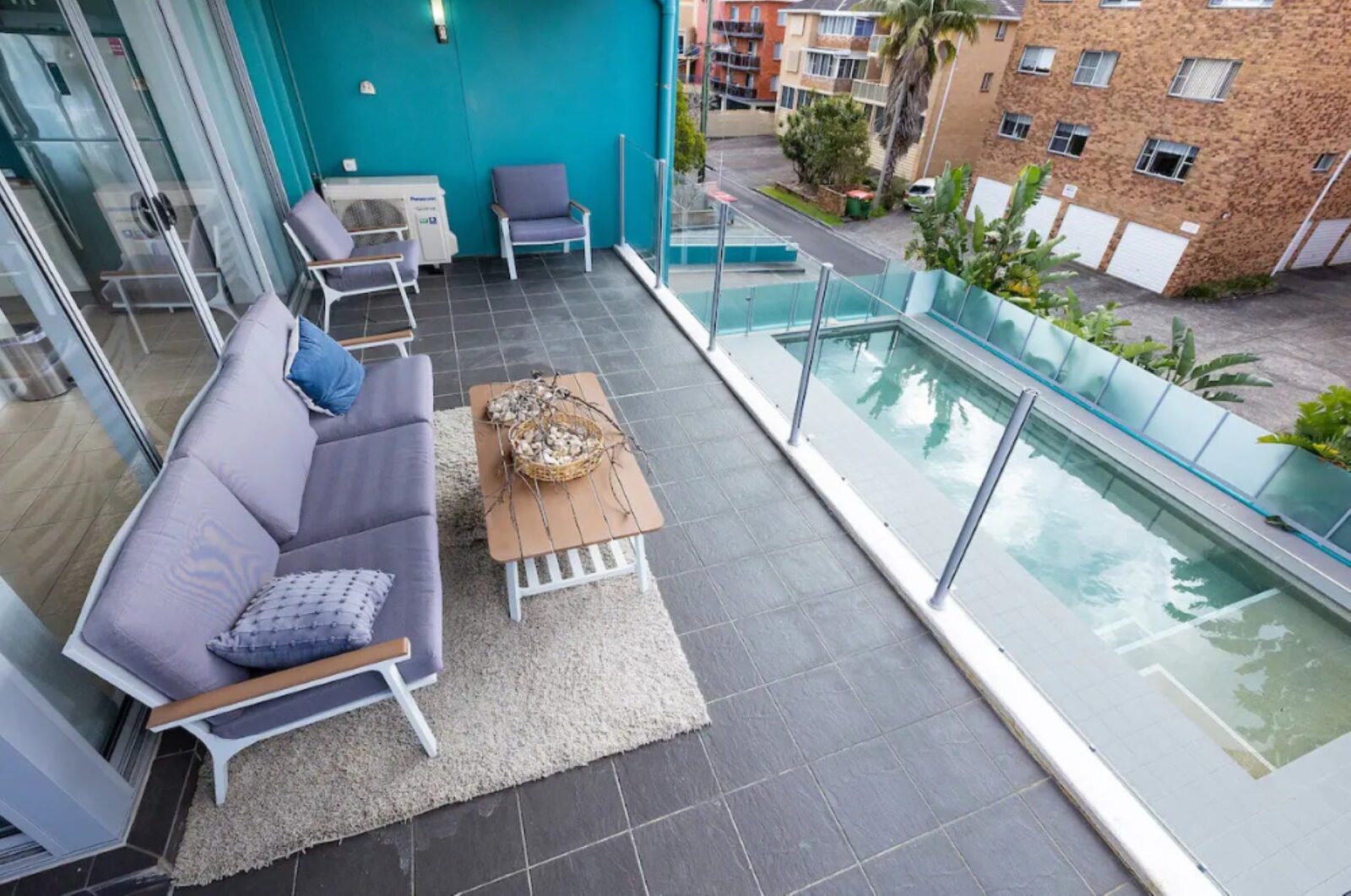 Balcony with casual lounge setting, overlooking pool