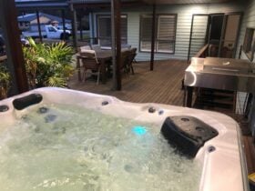 Front outdoor area with spa, bbq & dining setting
