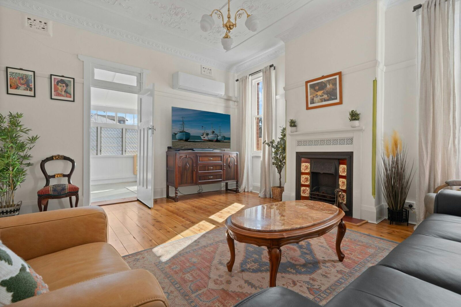 Living area with lots of character and antique furniture. Rug, coffee table, television and art.