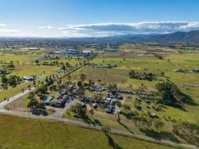 Aerial view of Tamworth Holiday Park surrounded by green fields, with the city in the distance and m