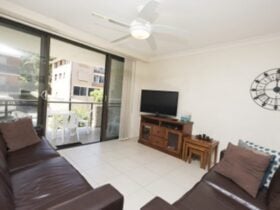Living area with ceiling fan, leading out to balcony