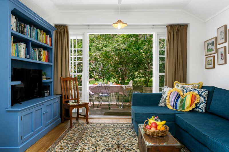 Living room with sofa bed, smart tv, ceiling fans, opens to courtyard