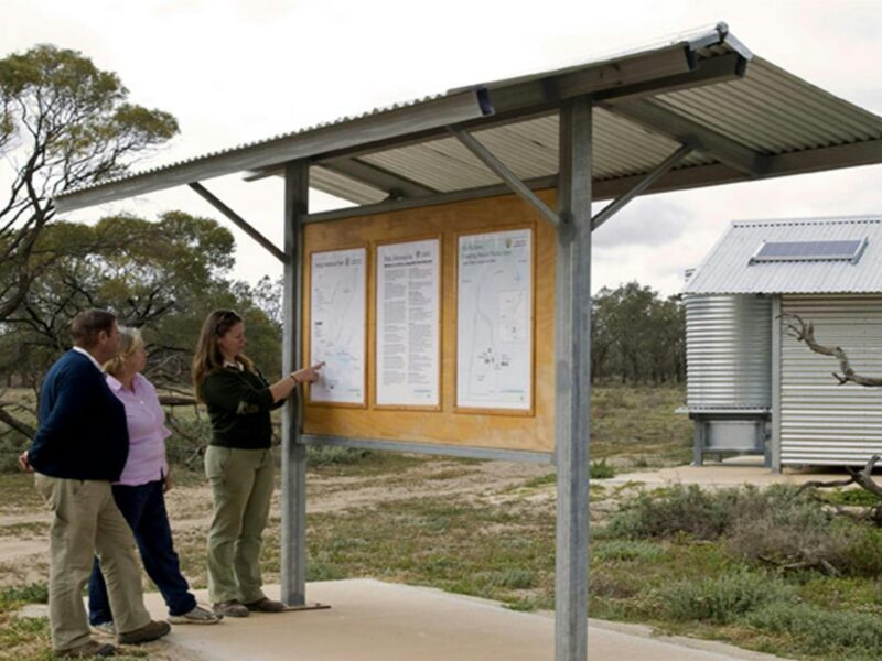 People reading a sign in the Willows campground. Photo: Boris Hlavica/NSW Government