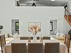 Indoor dining table set for 10 guests, with elegant chairs, warm lighting, and a stylish centerpiece