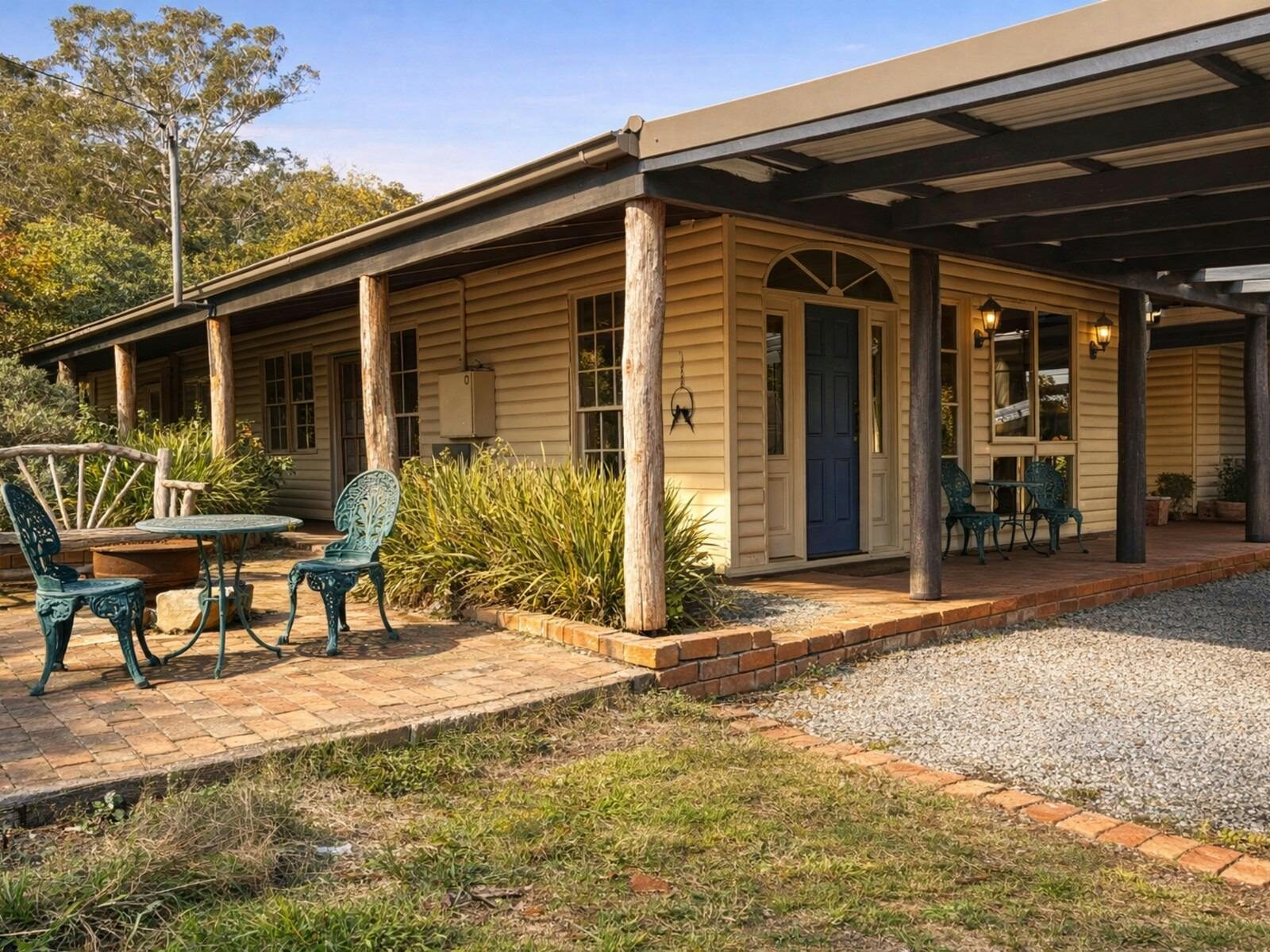 Wollemi Cottage at Widden Brook Farm showing the cottage exterior, covered veranda, blue front door