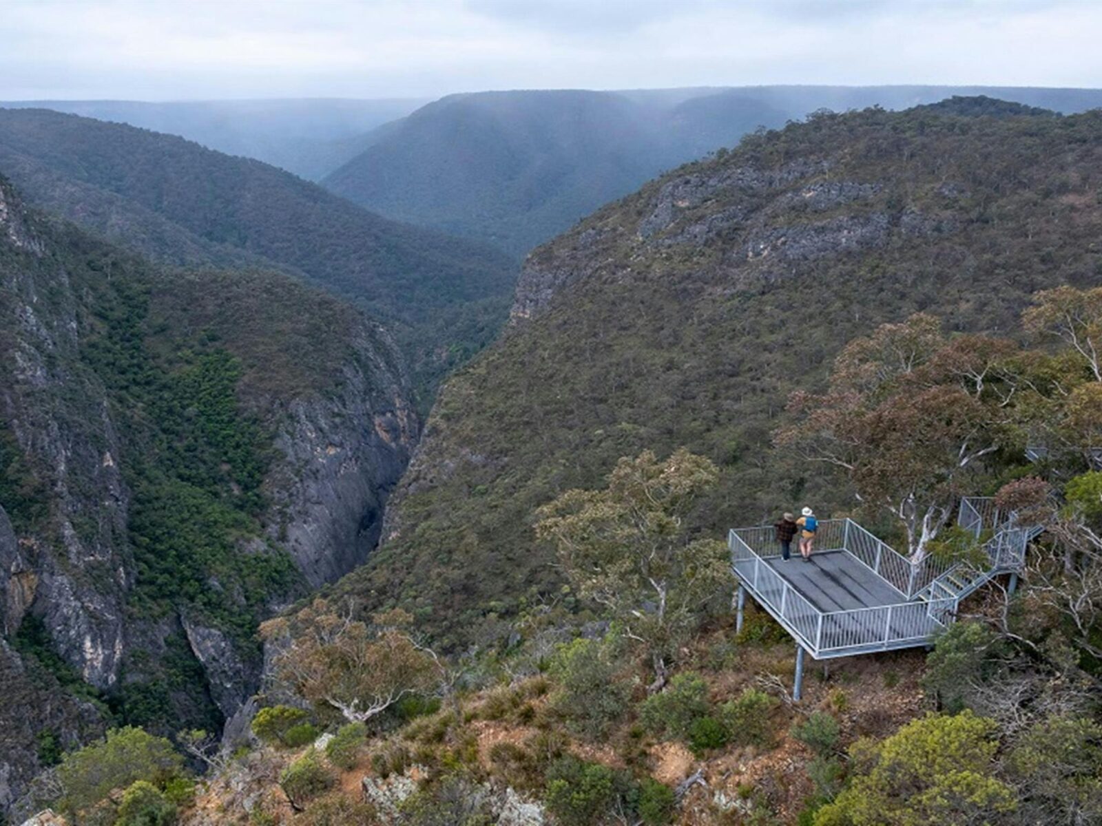 Aerial view of Adams lookout, with 2 people admiring the view over dramatic gorges, Bungonia