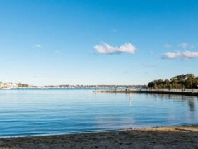 A view from the sands of a river with a blue reflection.