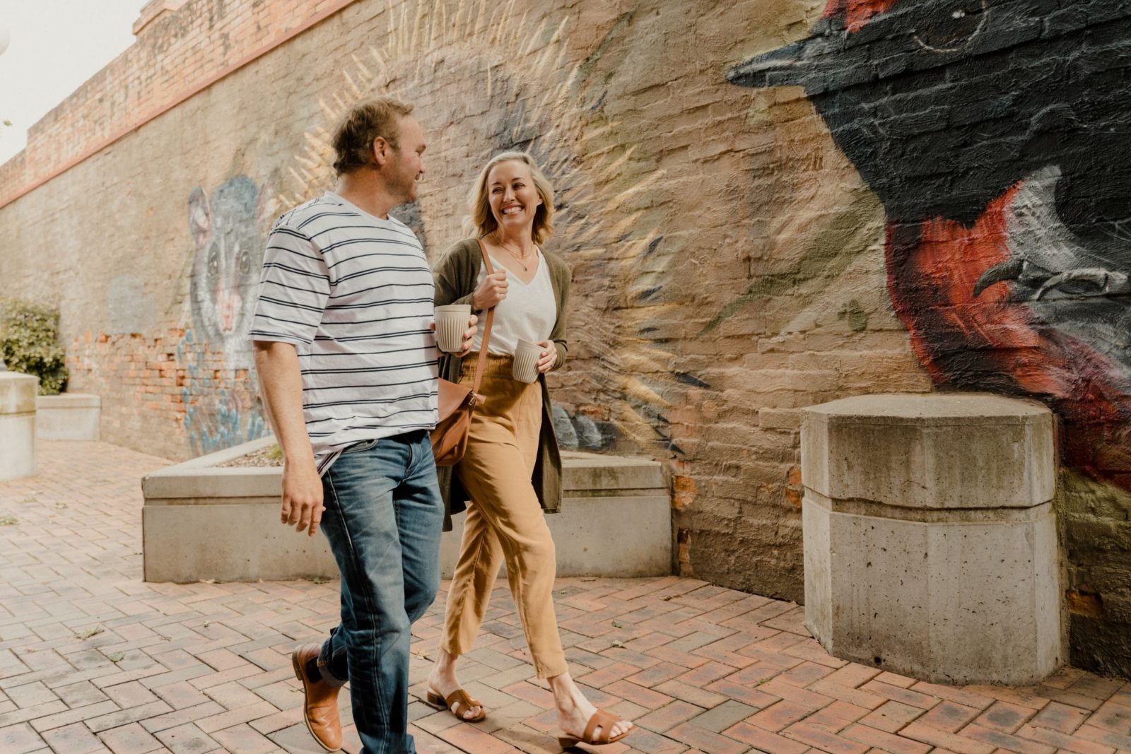 couple walking past native animal mural