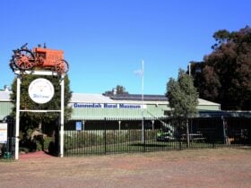 entry gate with tractor mounted on top and the museum building in the background