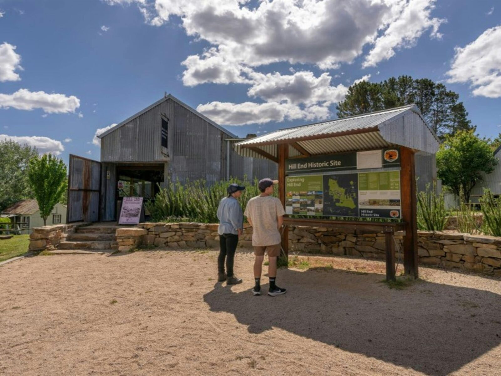Two visitors pause to read the interpretive sign outside Hill End Heritage Centre. Photo: John