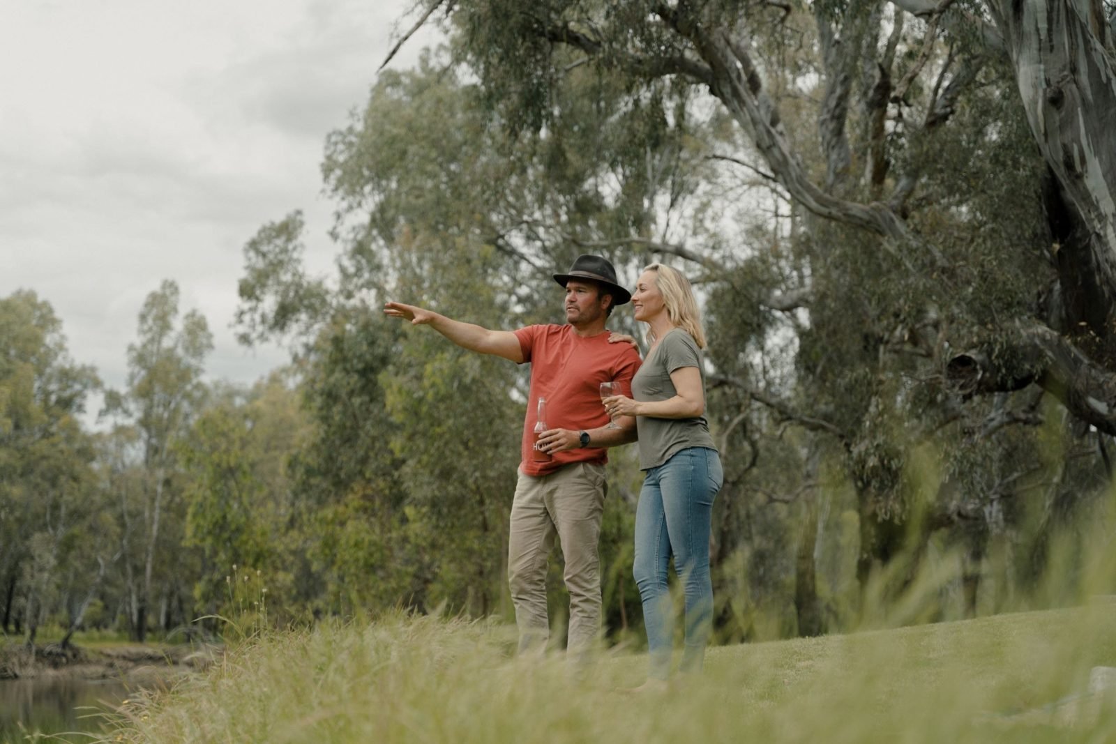 A man and woman look over the banks of the Murray River at Howlong.