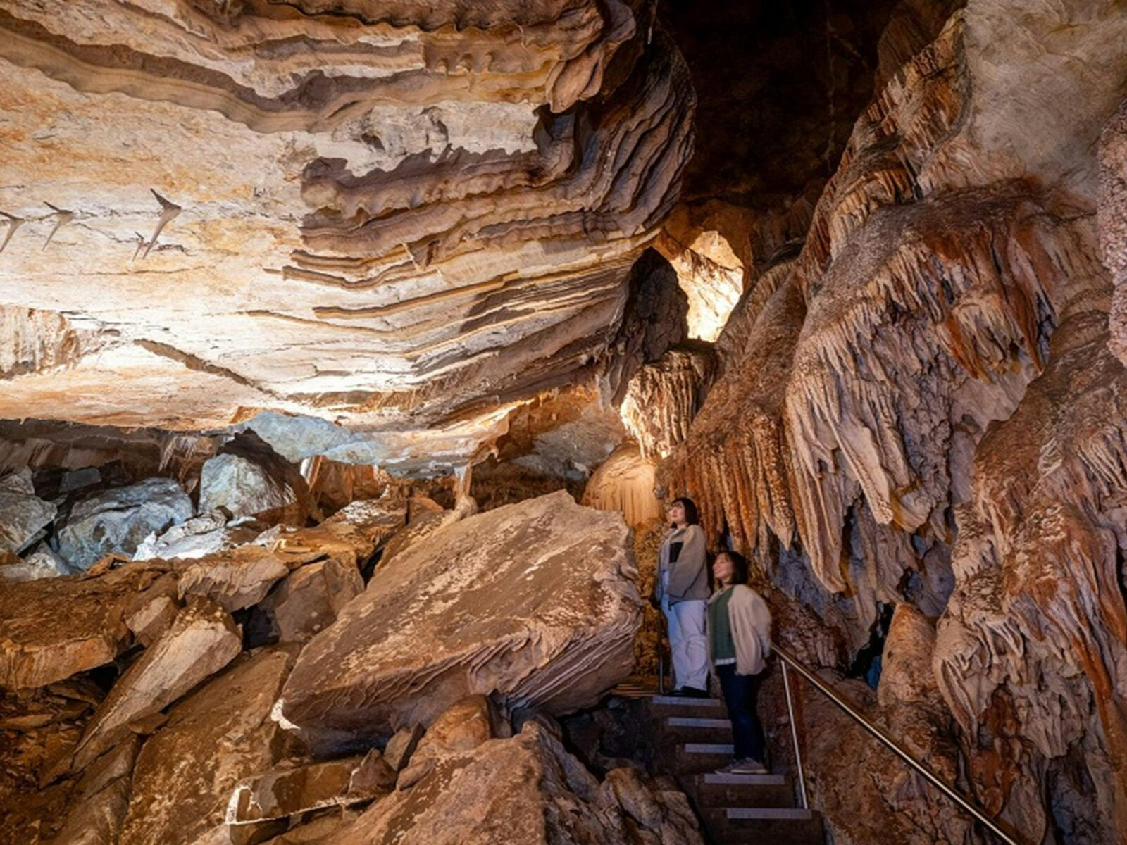 Two visitors exploring the caves at Jenolan. Photo: Jenolan Caves © DPE