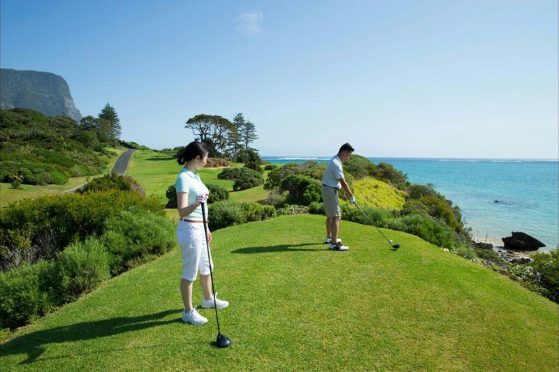 Couple enjoying a round of golf at Lord Howe Island Golf Course with ocean views