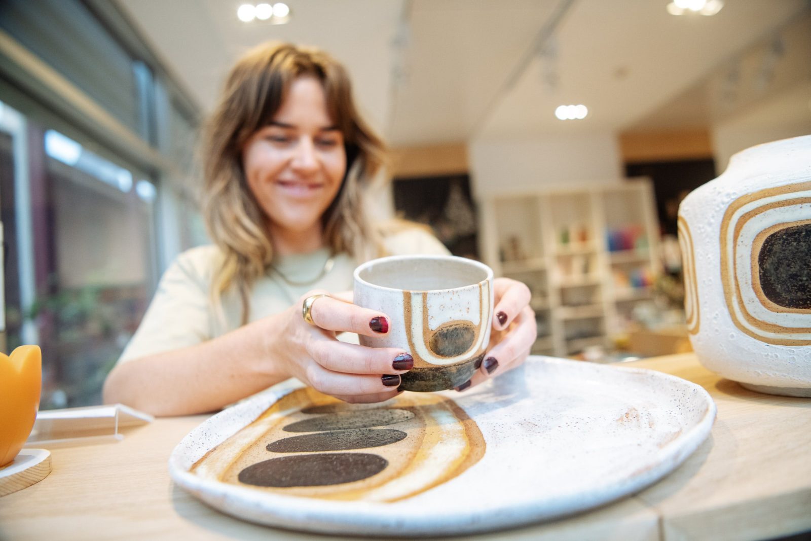 Woman picks up cup from ceramic platter