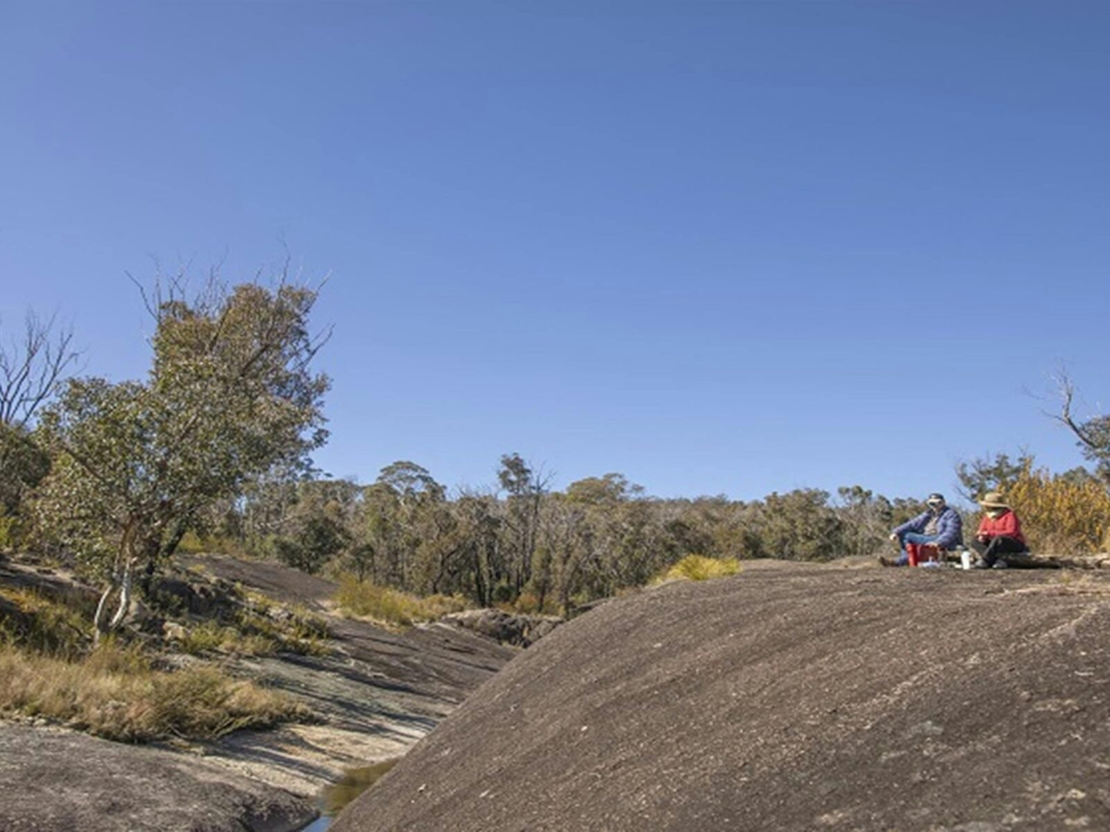 Visitors sitting on the granite rock formations at Morgans Gully picnic area. Photo: Joshua J Smith