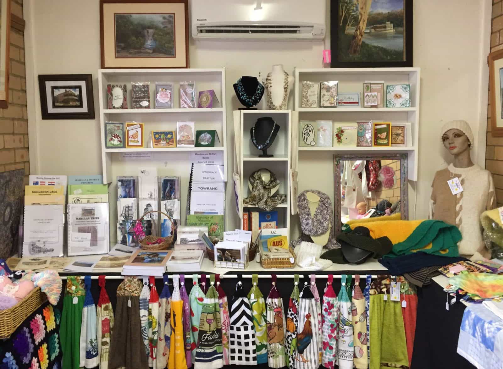 Display of handmade jewellery, towels, cards, kniteed jumpers and history books