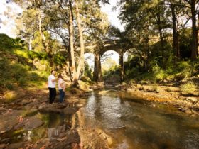 Couple looking at viaduct from a rock