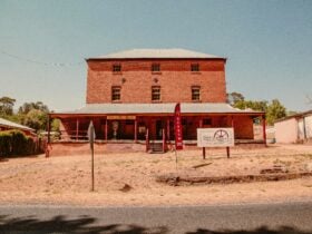triple story red brick building, tin roof
