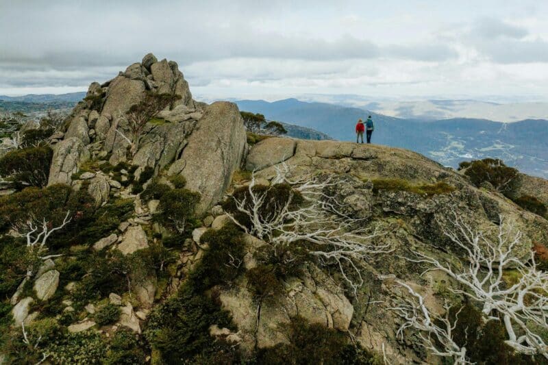 Two people explore Porcupine Rocks on the Snowies Alpine Walk.