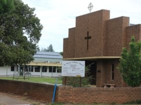The brick fence and building of St Fiacres Roman Catholic Church in Urana.