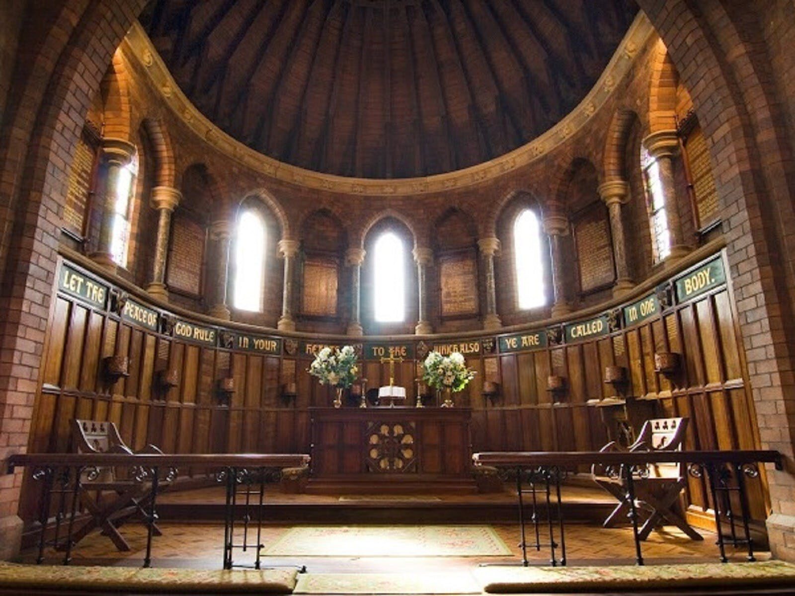 Interior of old church with arched windows and words on the walls
