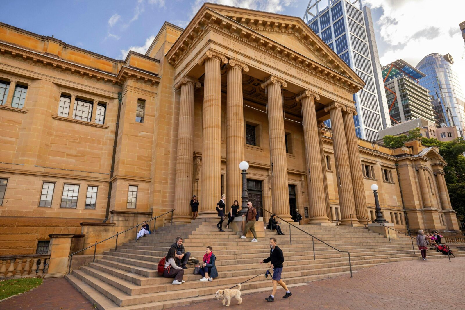 External of sandstone building with cityscape in background