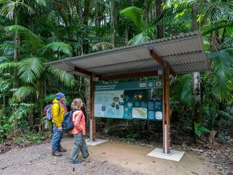 Visitors take in some of the story of this area at an information shelter, Terania Creek picnic area