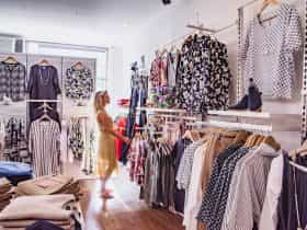 A woman looking at the women's clothes on display