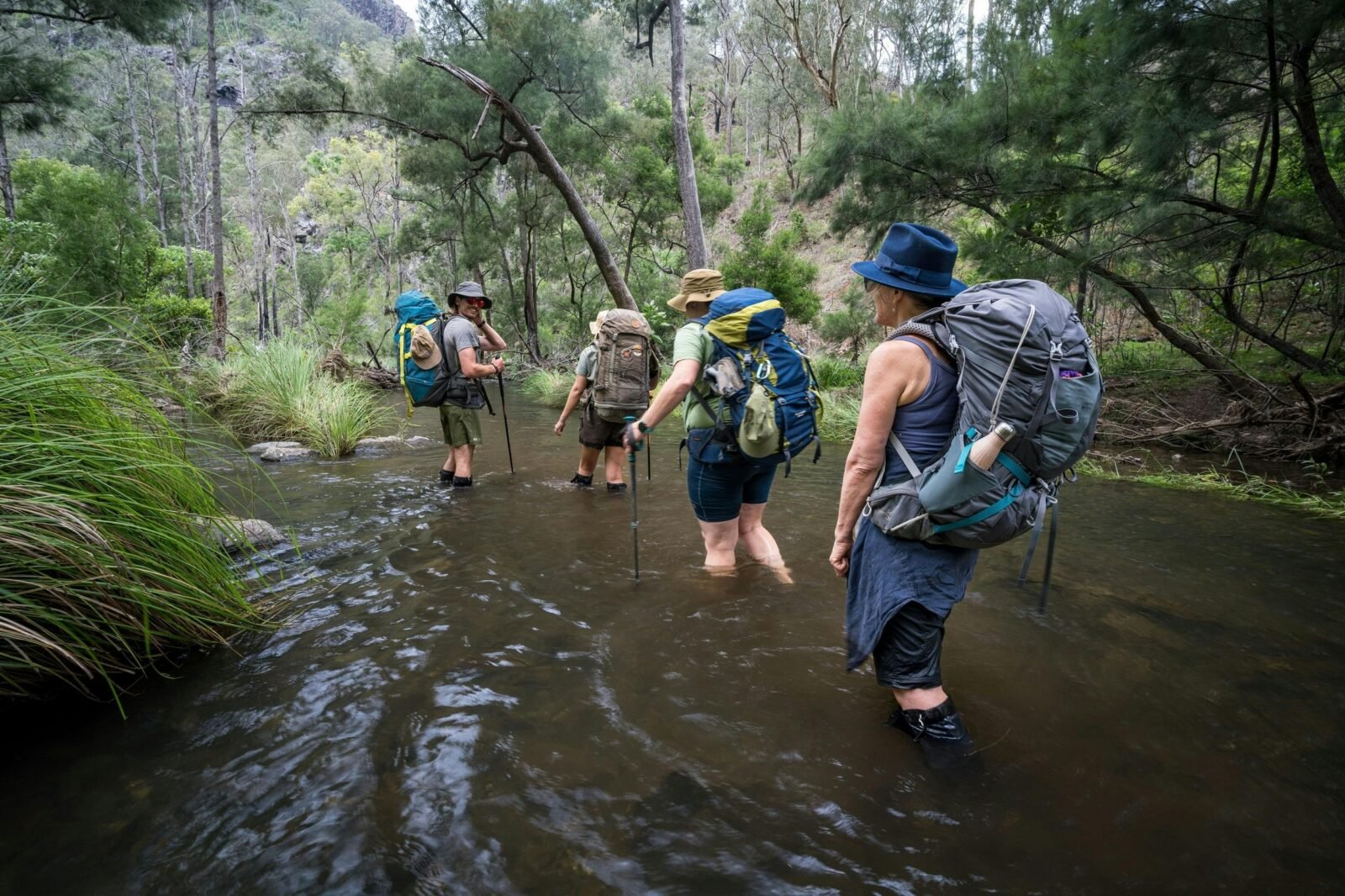A group of hikers crossing a river on Green Gully Track.