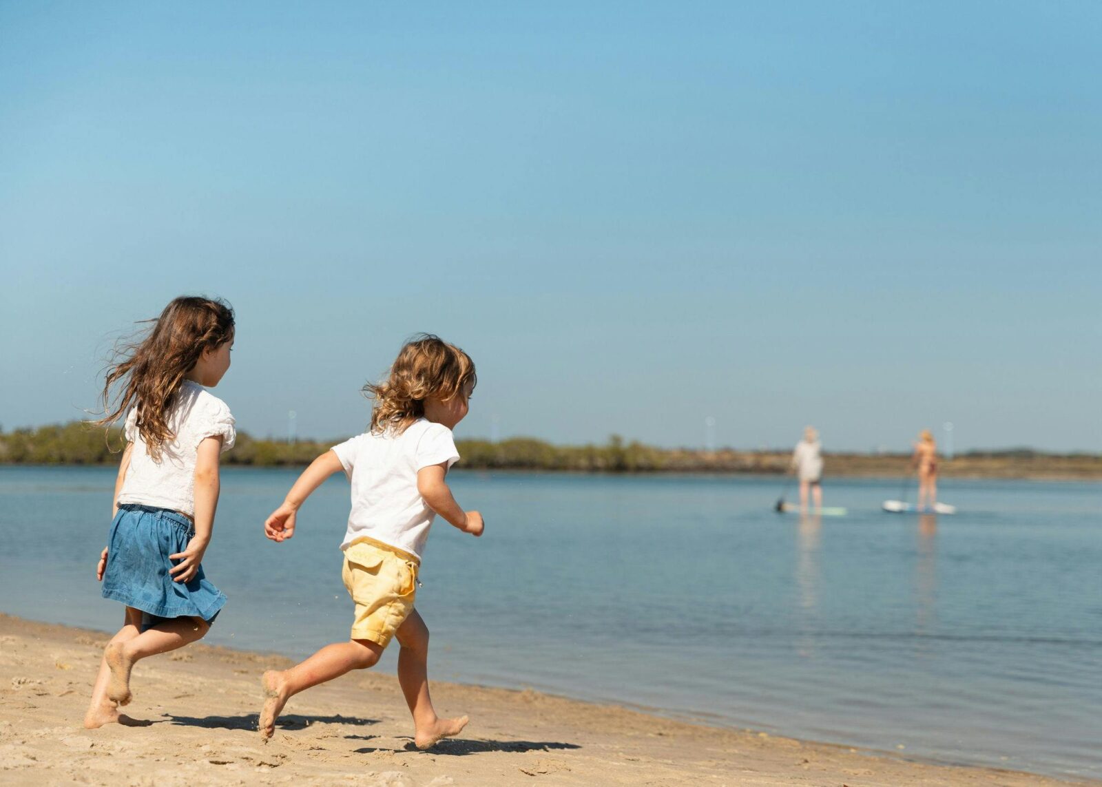 Two young children running into the water
