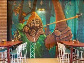 A Mural of Robin Hood A man in a cape with a bow and arrow