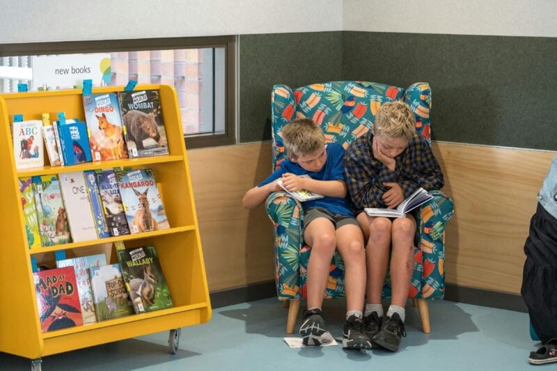 kids reading in the storytime chair in the library kids area.