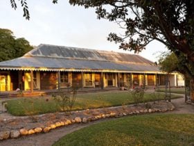 View of historic homestead with garden and pathways at twilight. Photo: David Finnegan © DPIE