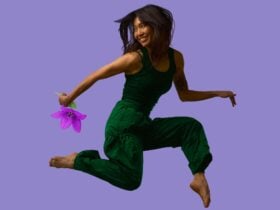 A woman jumping joyfully, holding a flower