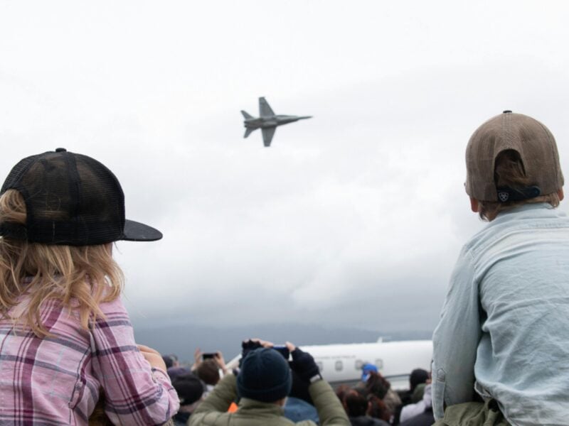 Plane flying in distance between two children