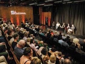 A panel of speakers and seated audience members