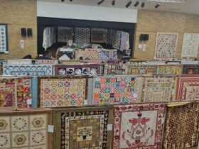 The dull hall is ringed by trade tables many from existing exciting Patchwork and quilting shops.