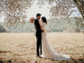 A bride and groom embrace as part of a romantic wedding scene.