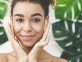 Happy smiling clean face with monstera leaves in bground