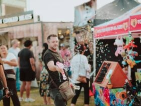 Man in a sideshow area selling bubble blowing guns