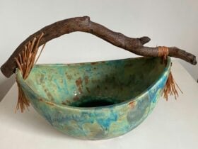 Bowl with a natural tree branch handle and leather fringinge