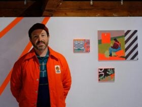 Artist Brett Piva standing next to his artwork
