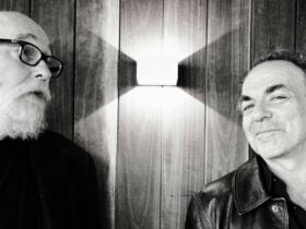 A black and white image of two males. One is looking directly into the camera and one isn't.
