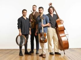 Four people standing and holding their instruments