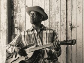 Eric Bibb. A man holding a guitar