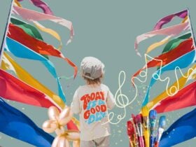 A child with a balloon animal in front of rainbow flags