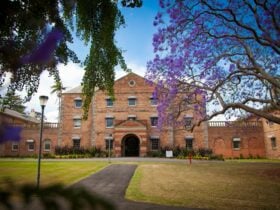 Front entrance of Female Orphan school with trees in foreground and path leading to the door