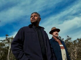 Artists standing together under trees and open blue sky