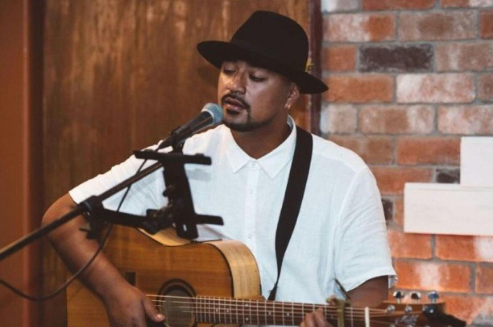 Image of a guitarist singing into a microphone