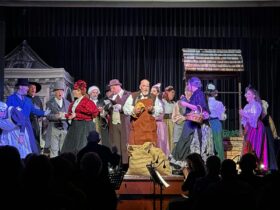 Full cast performing onstage